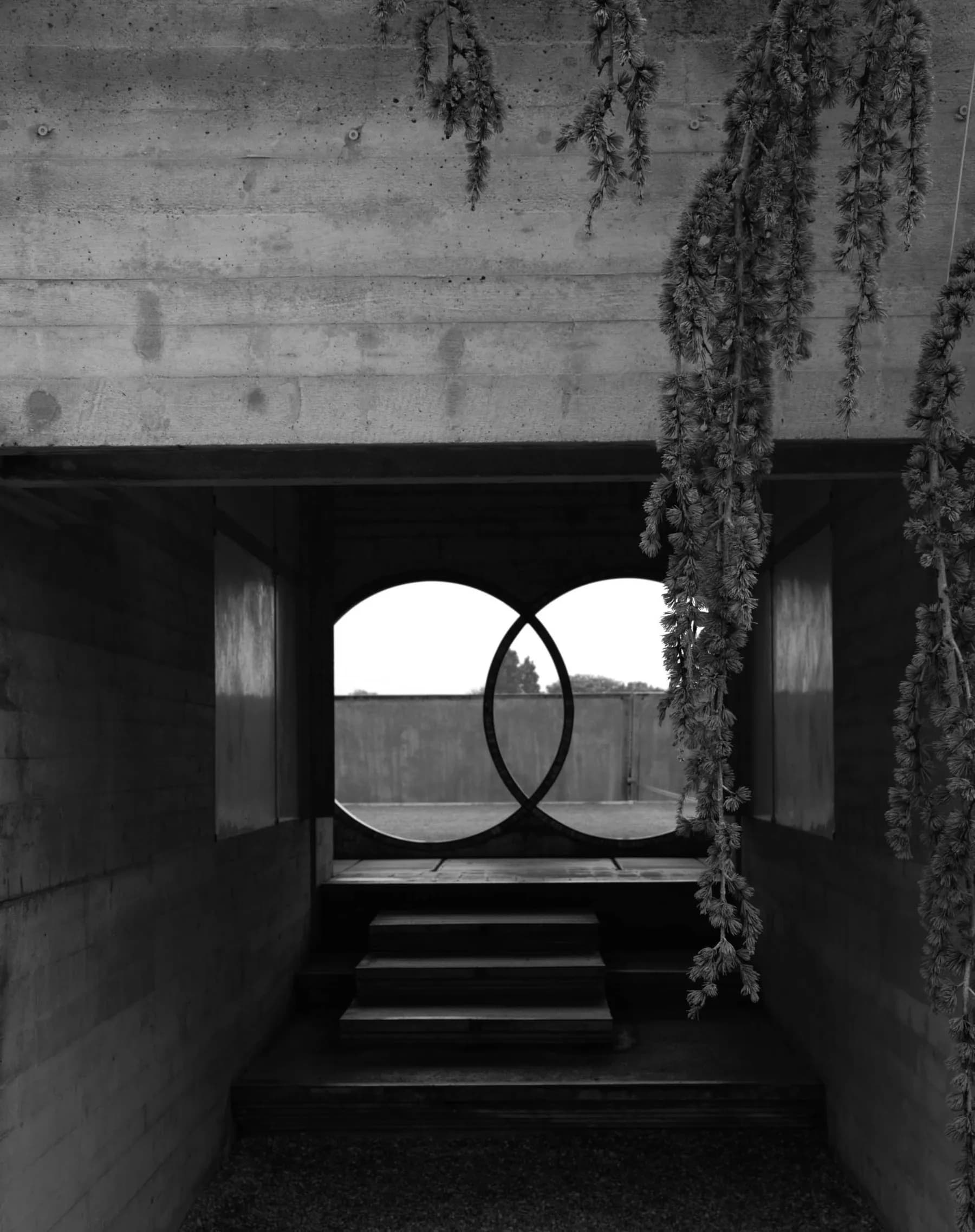 Two interlocking concrete rings seen through a shaded passage at Carlo Scarpa’s Brion sanctuary